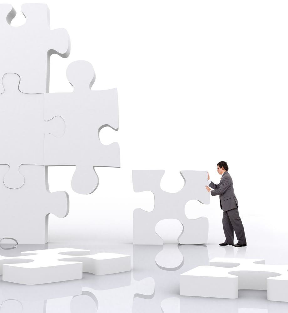 business man implementing a piece of a puzzle